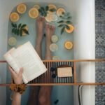 A tranquil bathtub with citrus fruits, book, and self-care essentials for relaxation.